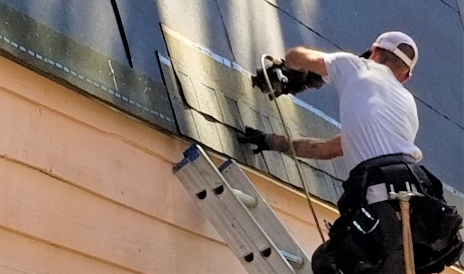 man on Ladder placing Roof Slates and Tiles. Professional roof fitters and roof repair services in Solihull.