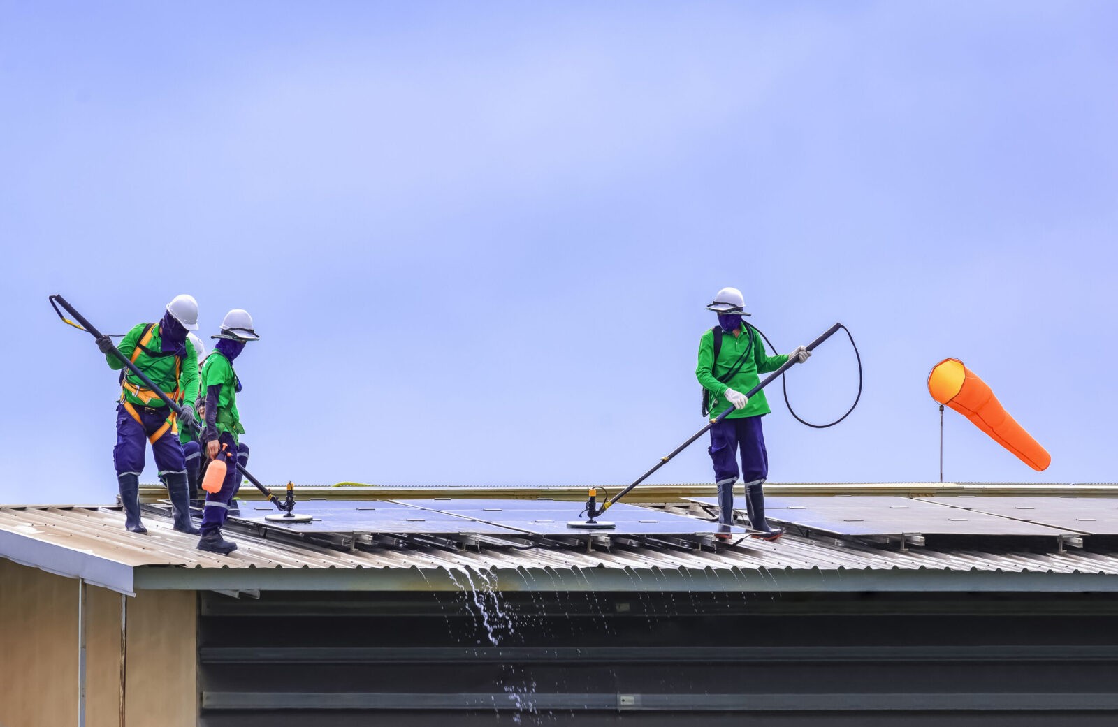 group of professionals roof cleaning solar panels