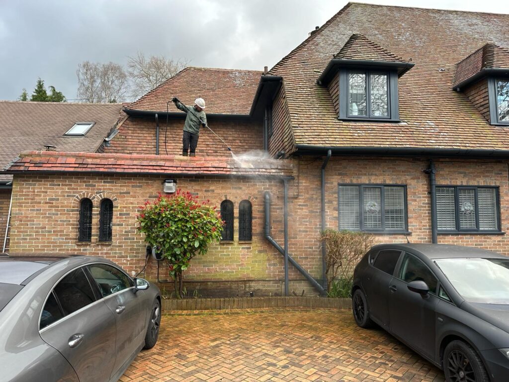 Seasonal Property maintenance - man on roof washing it down