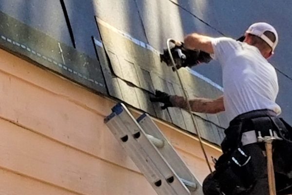man on Ladder placing Roof Slates and Tiles. Professional roof fitters and roof repair services in Solihull.