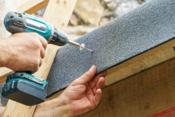 placing Screws into a Felt facia flat roof to complete damp-proofing roof repair and roof repairs job